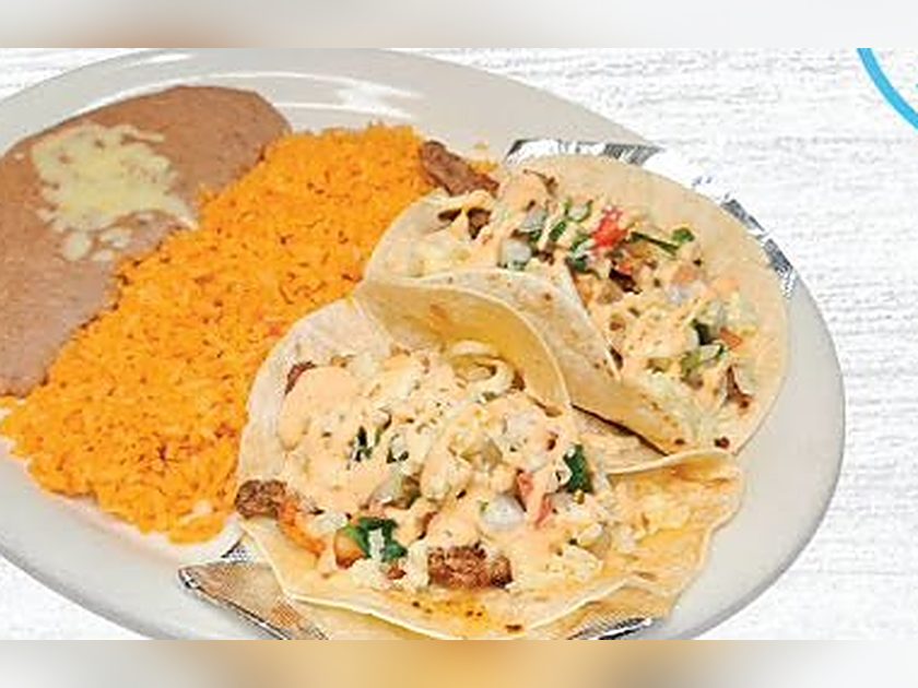 Steak and shrimp tacos plated with rice and beans